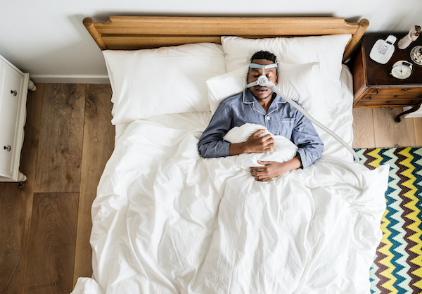 Man,Sleeping,With,An,Anti-snoring,Mask